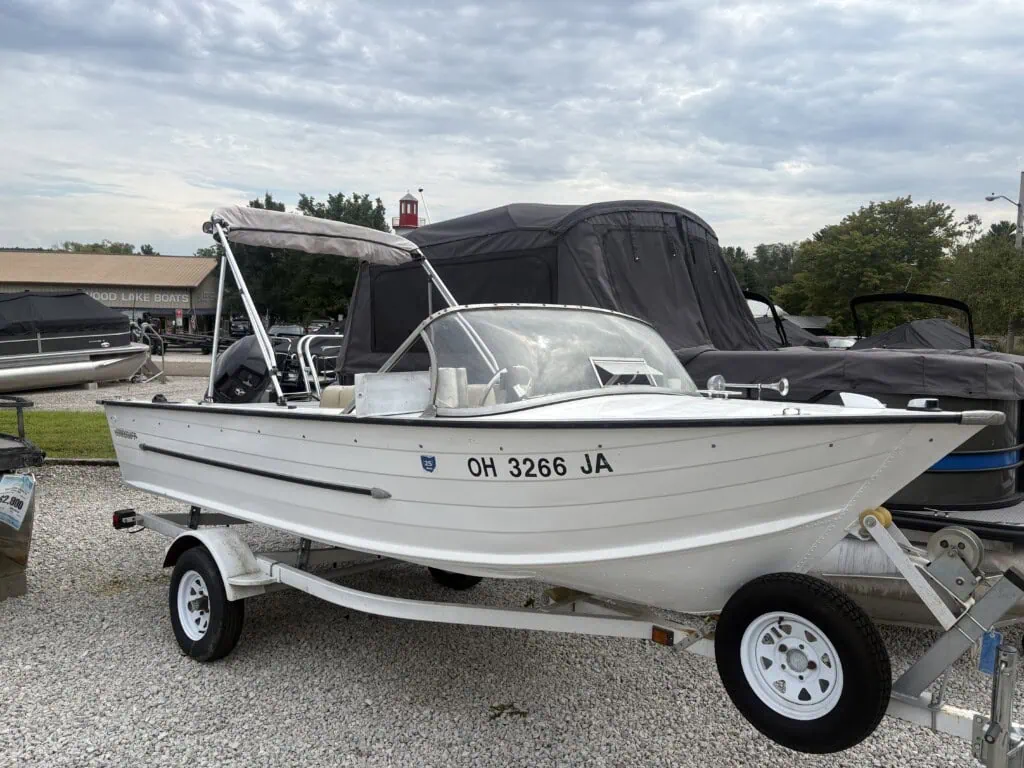 White motorboat on trailer at a boat dealership