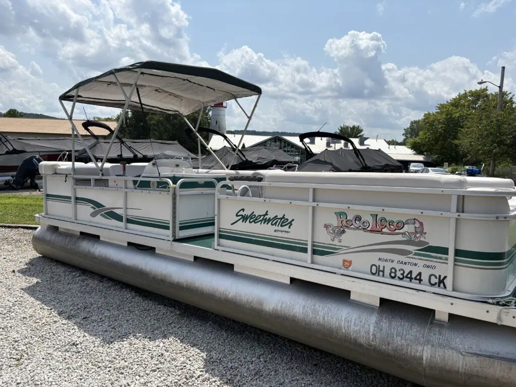 White Sweetwater pontoon boat with canopy at marina