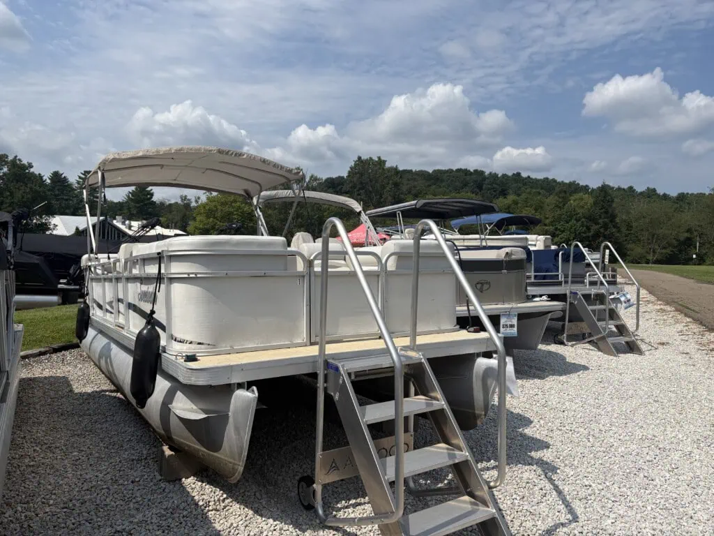 Pontoon boats on display at outdoor dealership lot