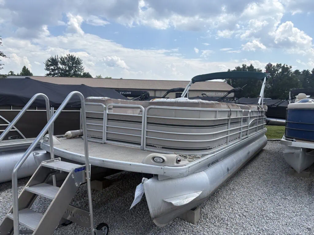 Pontoon boats displayed on gravel lot outdoors