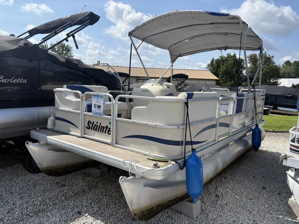 White pontoon boat with canopy at dealership