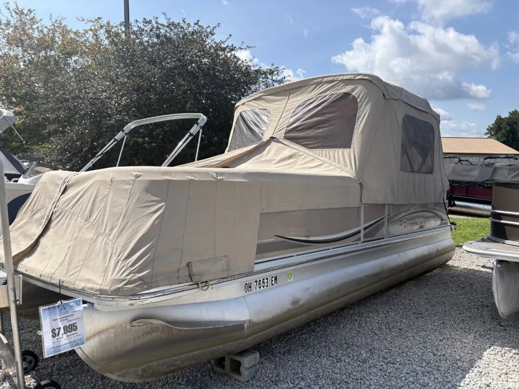 Covered Bennington pontoon boat displayed at outdoor dealership