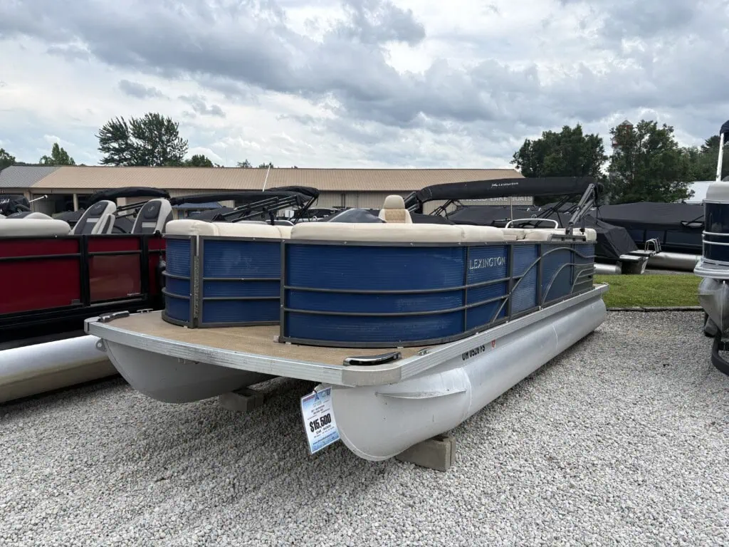 Blue Lexington pontoon boat on gravel lot