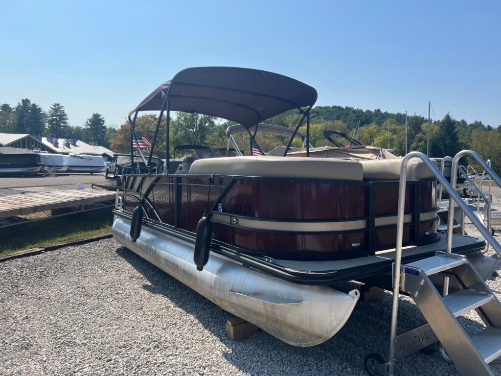 Maroon pontoon boat with canopy at a marina