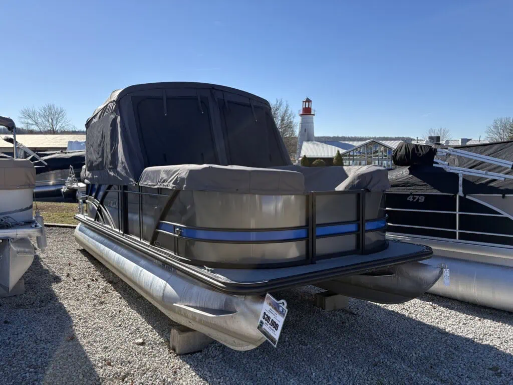Covered pontoon boat in a marina.