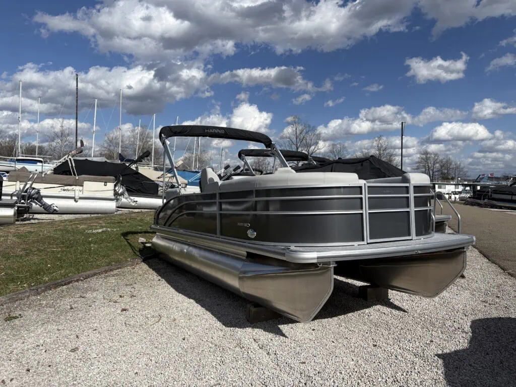 Pontoon boat parked on gravel lot