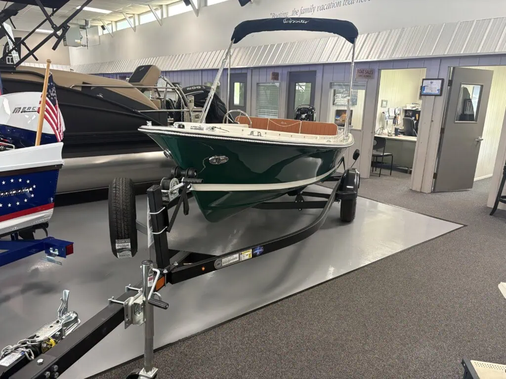 Green motorboat on trailer inside showroom
