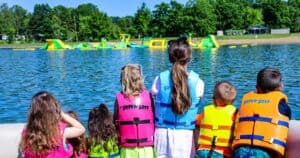 Kids on a boat at Atwood Lake looking at the Landzedge waterpark at Atwood Lake Park beach