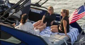 Group chatting on Barletta Lusso pontoon with American flag.