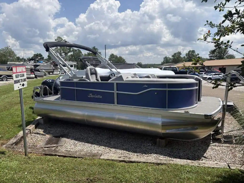 Blue pontoon boat parked near warning sign