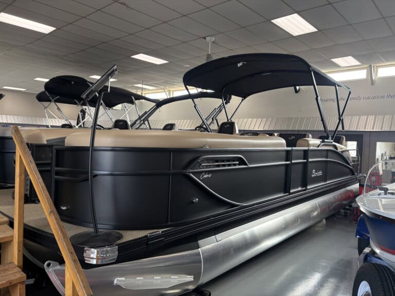 Black pontoon boat displayed in showroom
