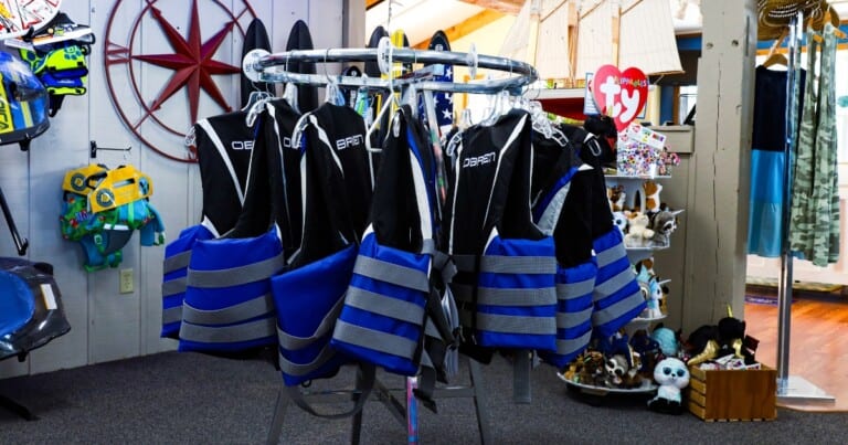 Colorful life jackets hanging in a store display.