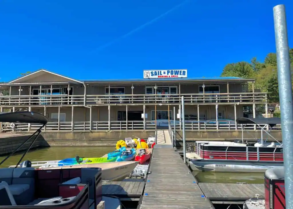 Sail N Power Marina building with boats and kayaks at dock.