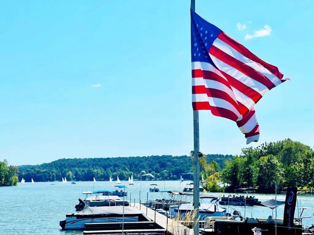 American flag over lakeside marina with boats